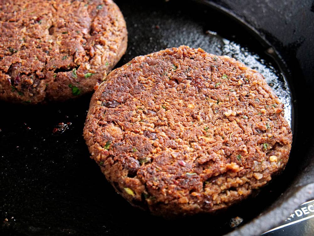 black Bean burgers being cooked in a frying pan