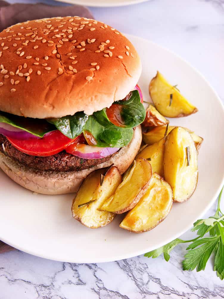 black bean quinoa burgers on a white plate served with fries