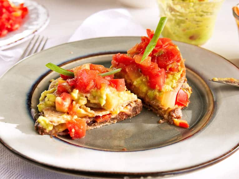 vegetarian healthy quesadillas with black beans served on a plate, cut in half
