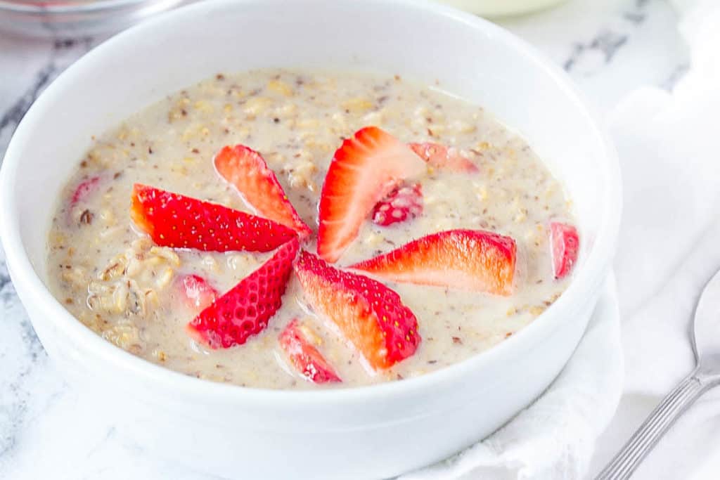 strawberries and cream oatmeal, strawberry oatmeal in a white bowl