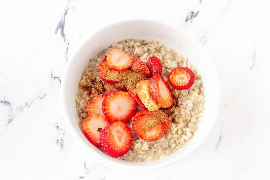 strawberries added to oats in a bowl