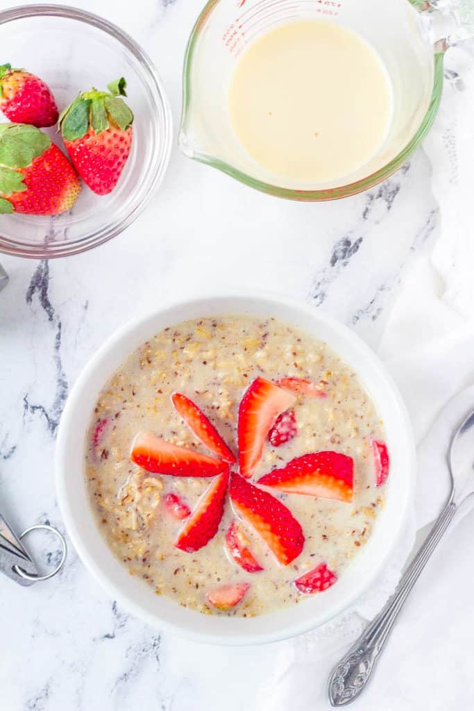 strawberries and cream oatmeal, strawberry oatmeal in a white bowl