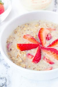 strawberries and cream oatmeal, strawberry oatmeal in a white bowl