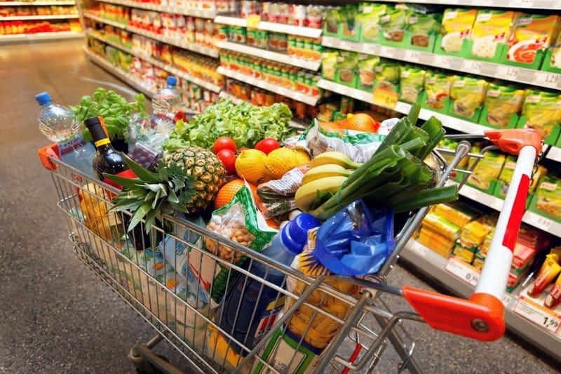 grocery cart filled with fresh produce and other healthy groceries - budget grocery shopping tips