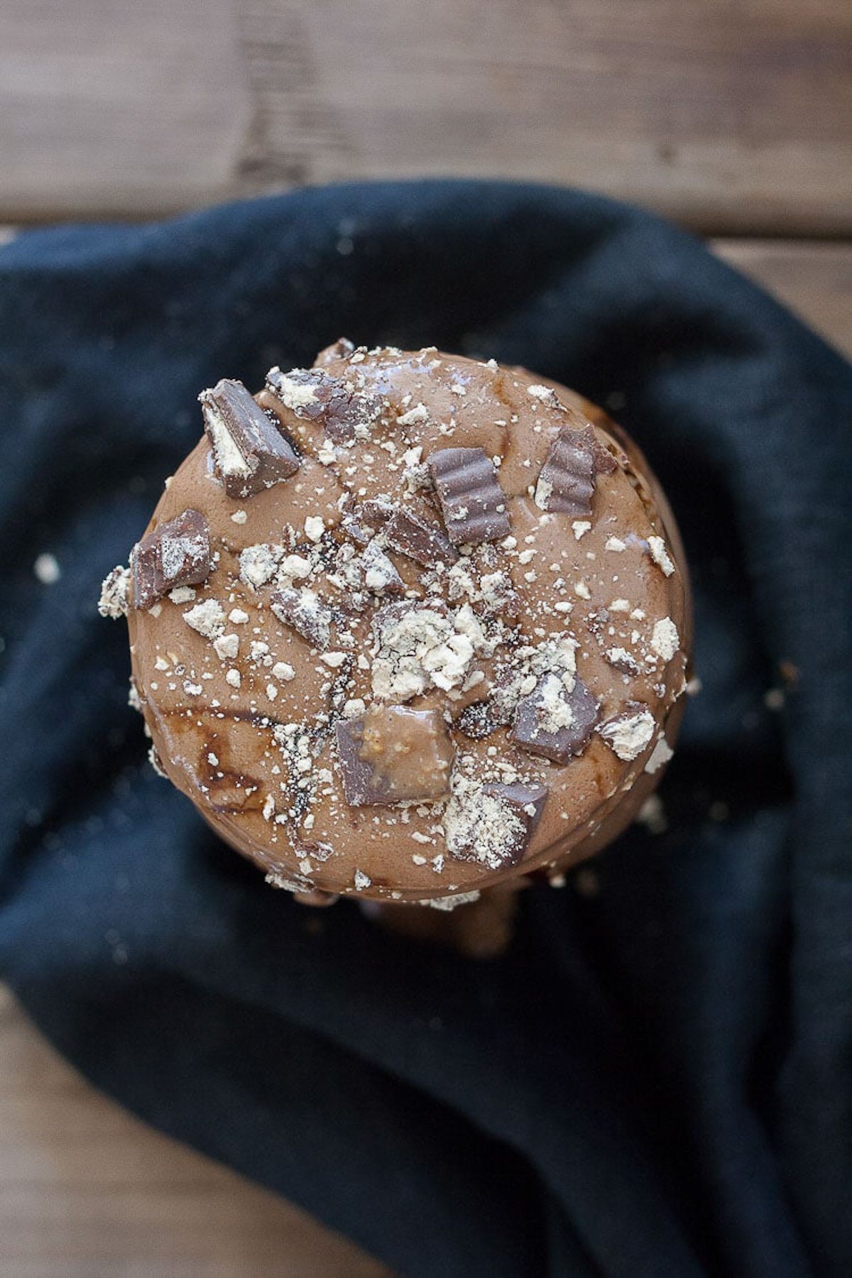 top view of a peanut butter cup milkshake in a mason jar with crumbled peanut butter cup pieces on top