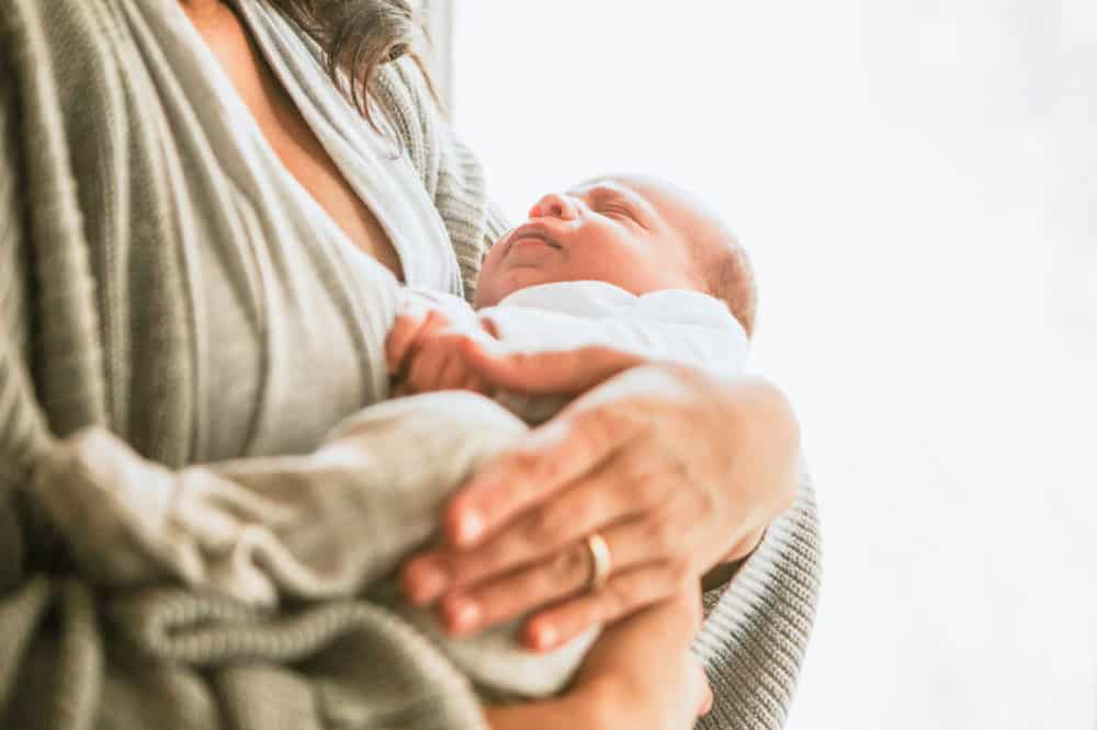 mom holding a baby in her arms - advice for new moms