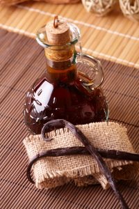 Vanilla extract with beans on natural background