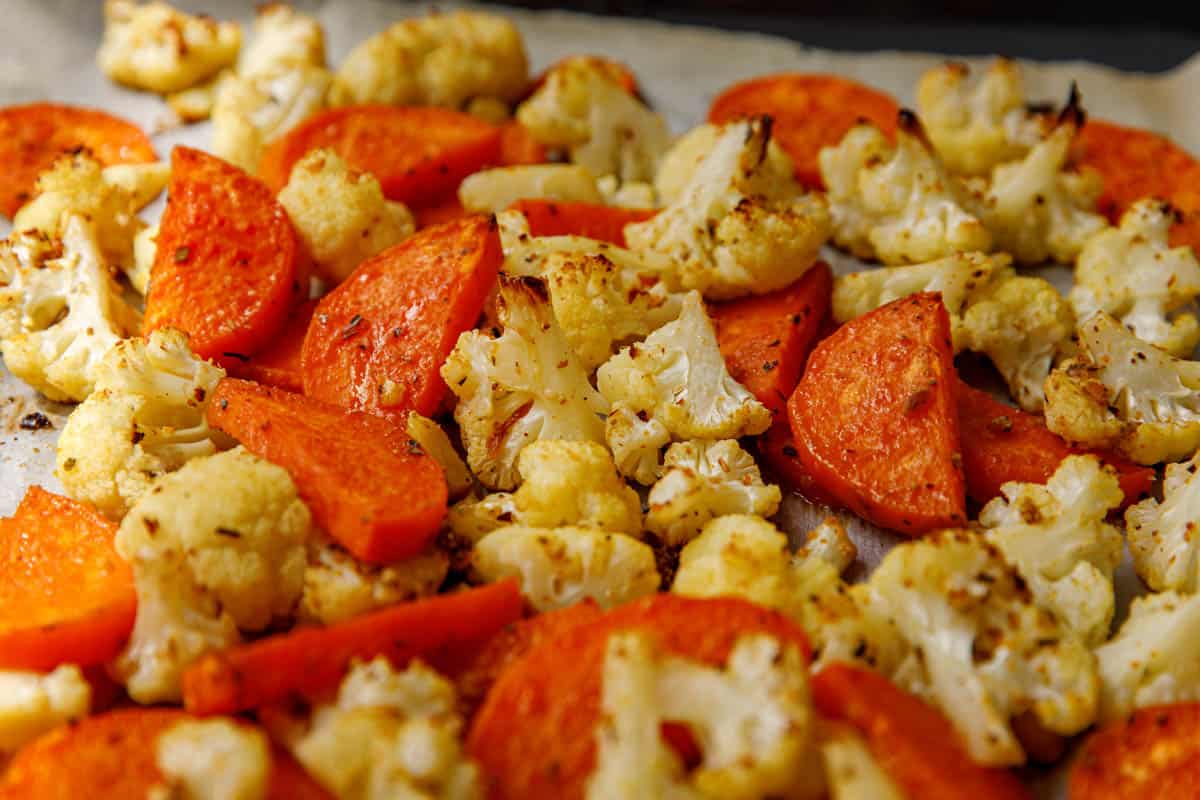 Roasted cauliflower and carrots on a baking sheet.