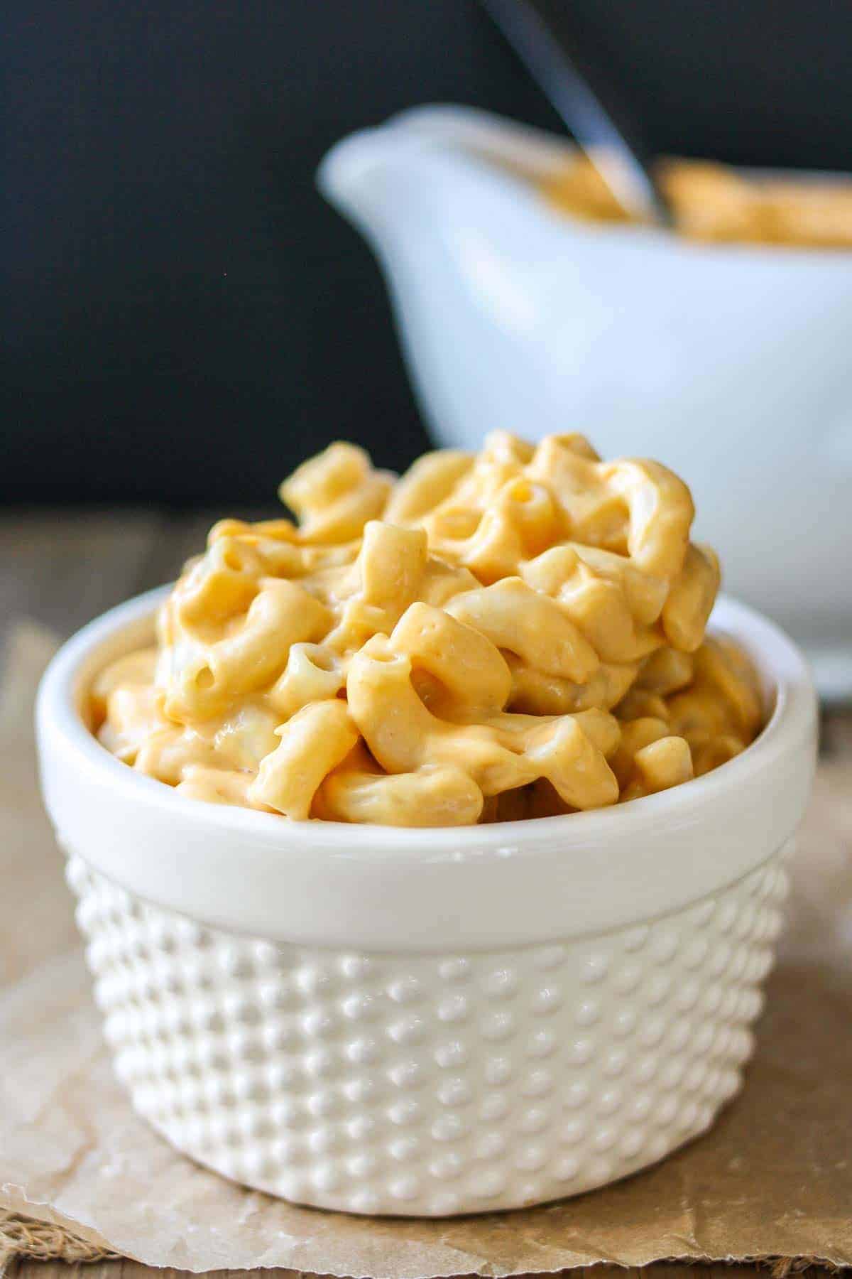 White textured bowl filled with creamy orange mac and cheese, tossed with a vegan cheese sauce.