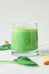 spinach ginger smoothie served in a glass against a white background