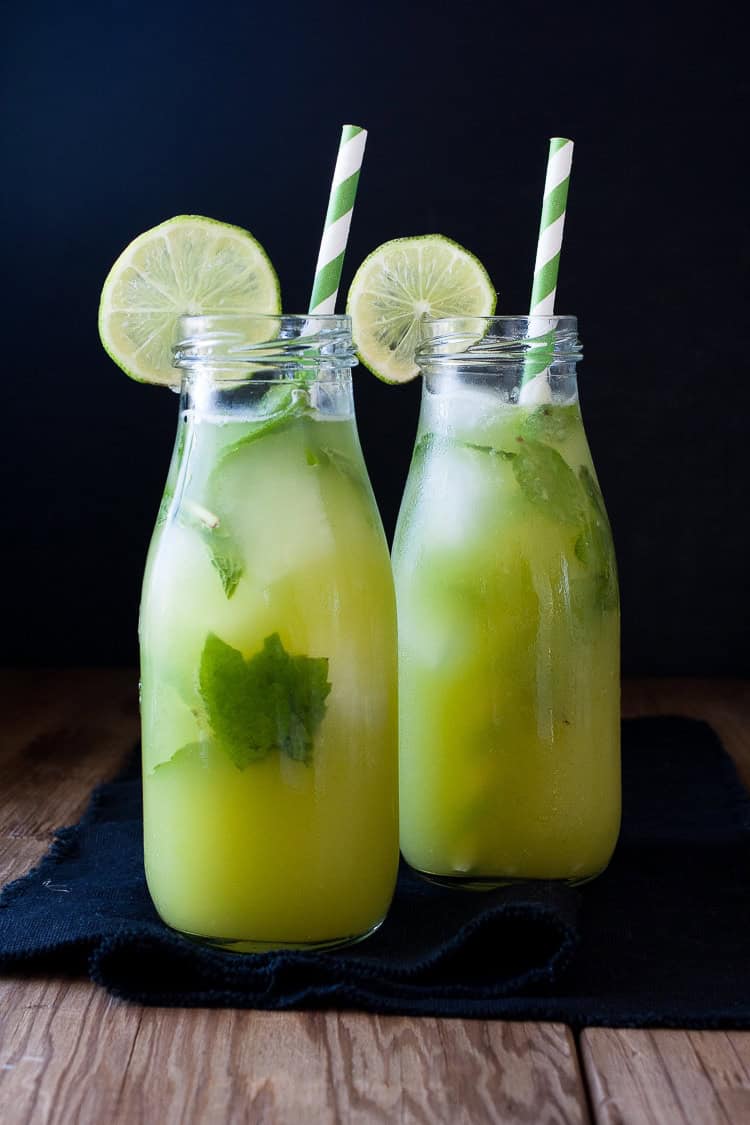 Fresh anti-inflammatory juice in two bottles with straws on a wooden surface Fresh anti-inflammatory juice in two bottles with straws on a wooden surface