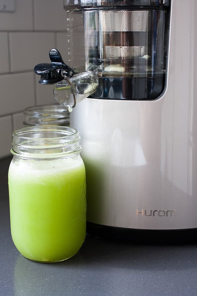 Fresh anti-inflammatory juice coming out a juicer and filling a glass Fresh anti-inflammatory juice coming out a juicer and filling a glass