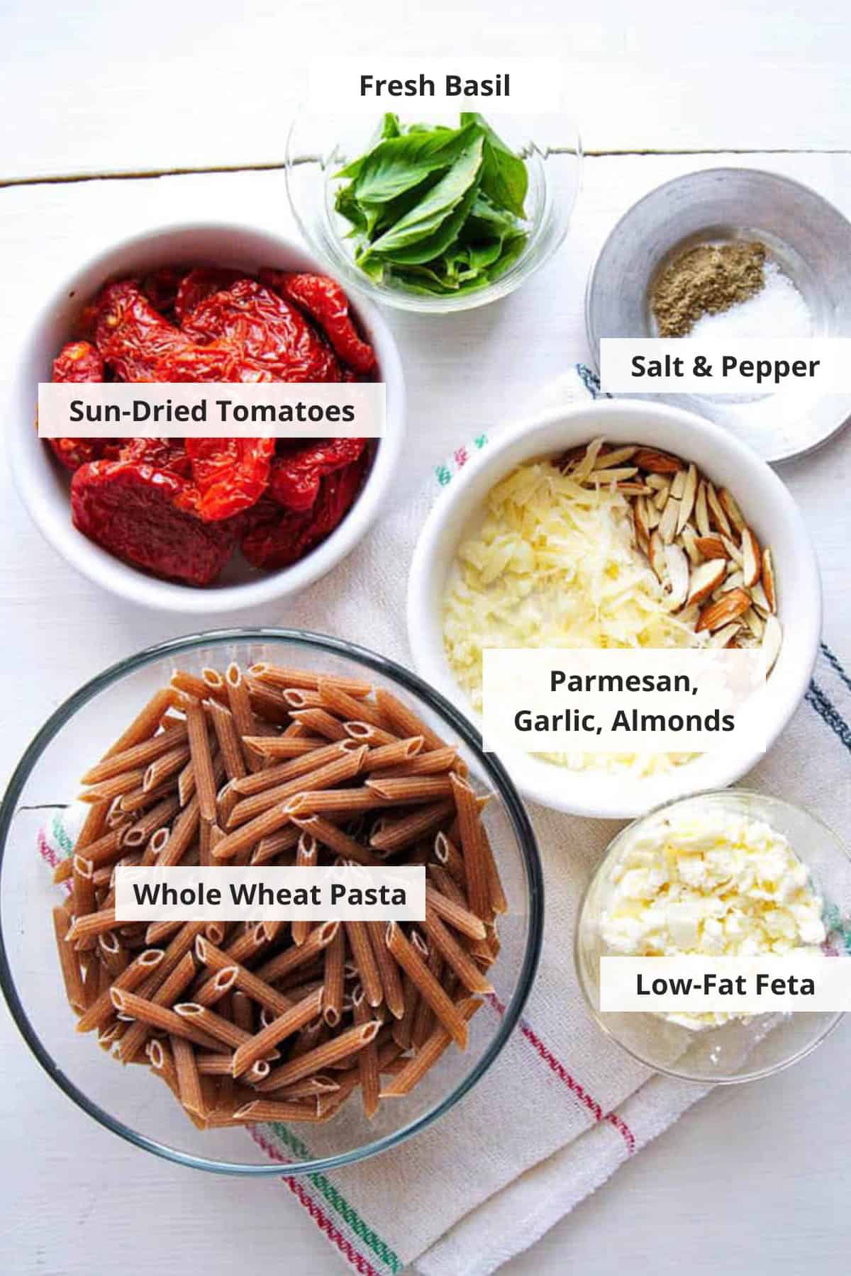 Ingredients for sun dried tomato feta pasta recipe on a white countertop.
