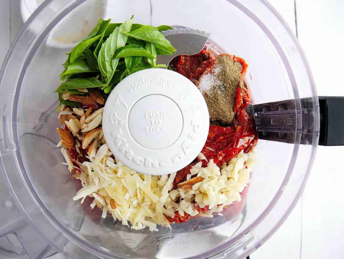 Sun dried tomatoes, basil, cheese, almonds and spices added to a food processor.