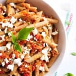 Sun dried tomato feta pasta served in a white bowl.