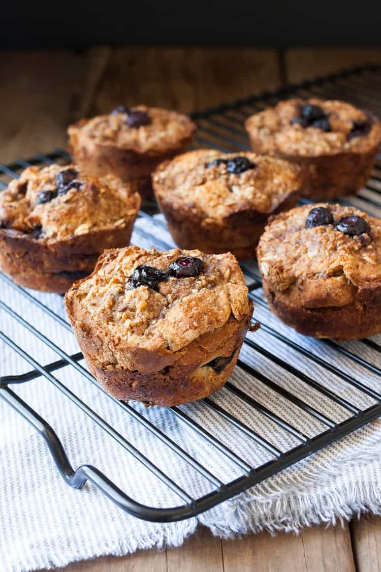 Mixing up breakfast in the most delicious way with blueberry flavored french toast made into vegan breakfast muffins! Easy to put together and prep ahead. #veganbreakfastrecipes #veganmuffins #sponsored #LoveMySilk Wire cooling rack filled with blueberry french toast muffins sitting on grey striped towel