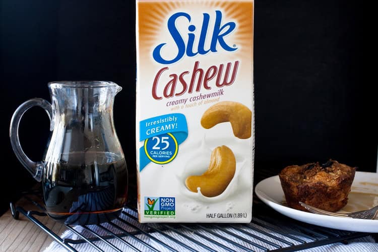 Mixing up breakfast in the most delicious way with blueberry flavored french toast made into vegan breakfast muffins! Easy to put together and prep ahead. #veganbreakfastrecipes #veganmuffins #sponsored #LoveMySilk Carton of Silk cashew milk next to jar of maple syrup and French Toast muffin