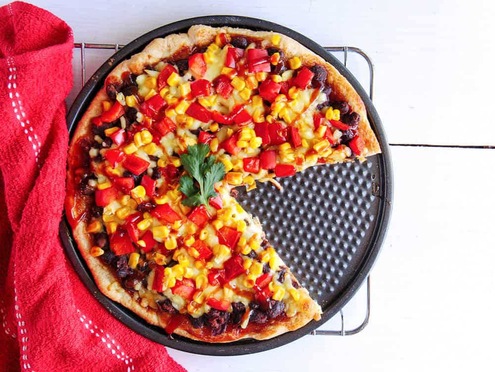 Black bean and corn pizza with a slice missing - bbq flatbread pizza