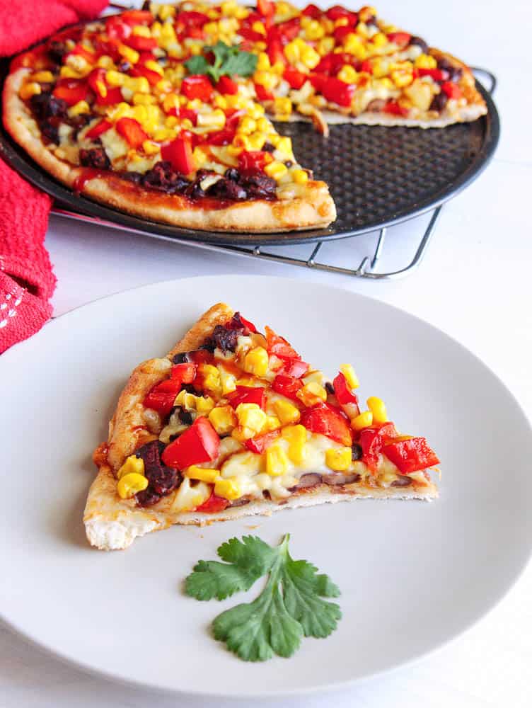 A slice of black bean and red pepper pizza on a white plate - bbq flatbread pizza