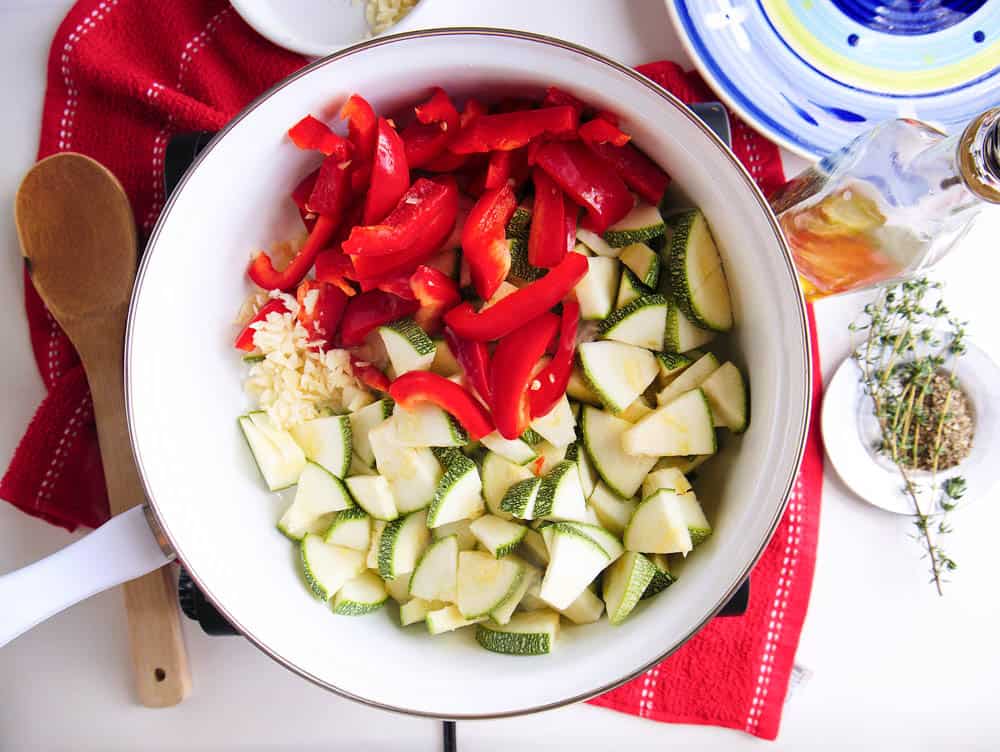zucchini and red peppers added to the pan