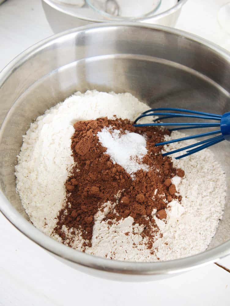 Flours, cocoa and salt whisked together in a large silver mixing bowl.