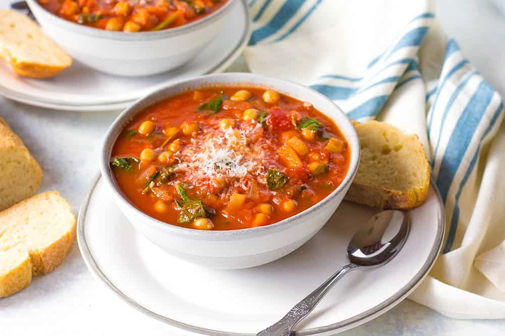 Italian Chickpea Soup served in a white bowl with a slice of bread