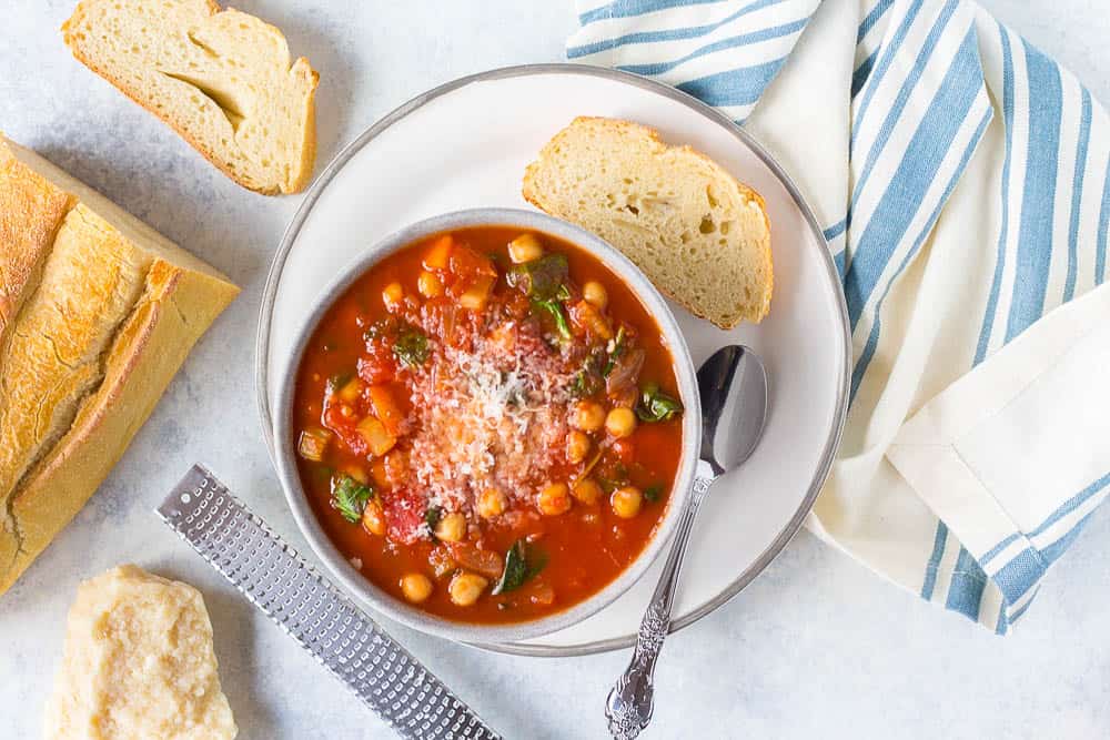 Top shot of Italian chickpea soup served in a white bowl with crusty bread