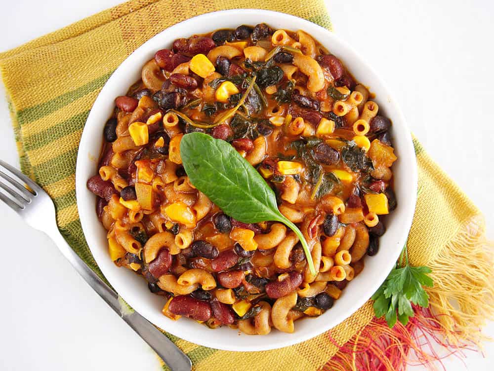 Instant Pot Vegetarian Chili Mac in a white bowl garnished with a green leaf