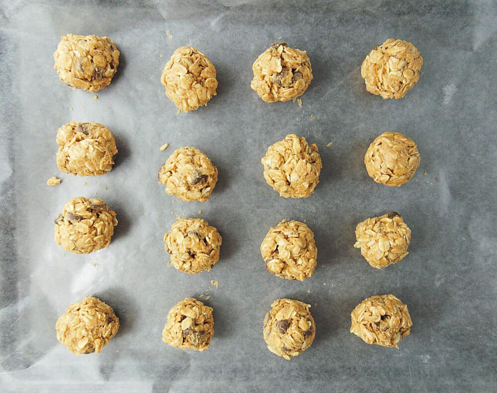 No Bake Peanut Butter Balls placed on a parchment paper on a baking sheet