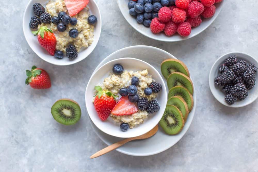 oatmeal with fresh berries in a white bowl, top view