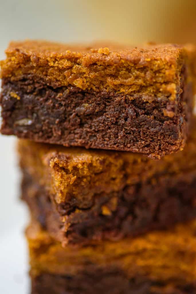 closeup of layered pumpkin brownies, cut and stacked on top of each other