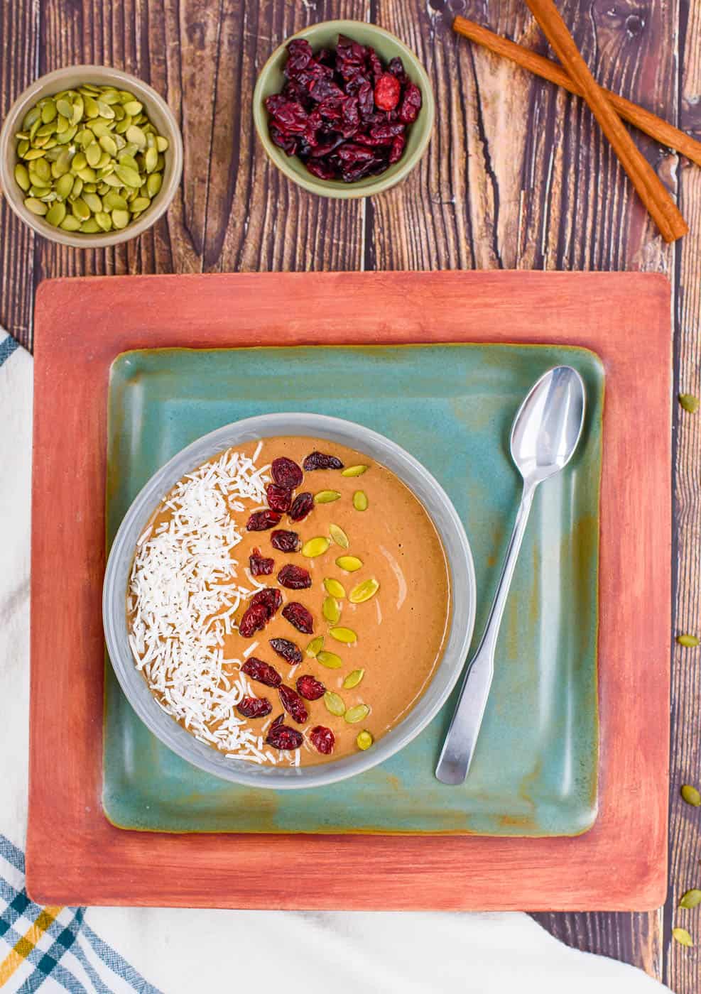 pumpkin smoothie bowl - pumpkin spice latte smoothie bowl, with pumpkin seeds and cranberries on top, top view