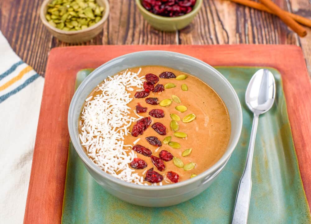 pumpkin smoothie bowl - pumpkin spice latte smoothie bowl, with pumpkin seeds and cranberries on top, top view