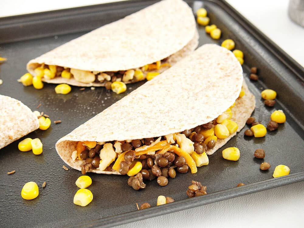 vegetarian quesadillas with cumin and lentils - being assembled on a baking sheet