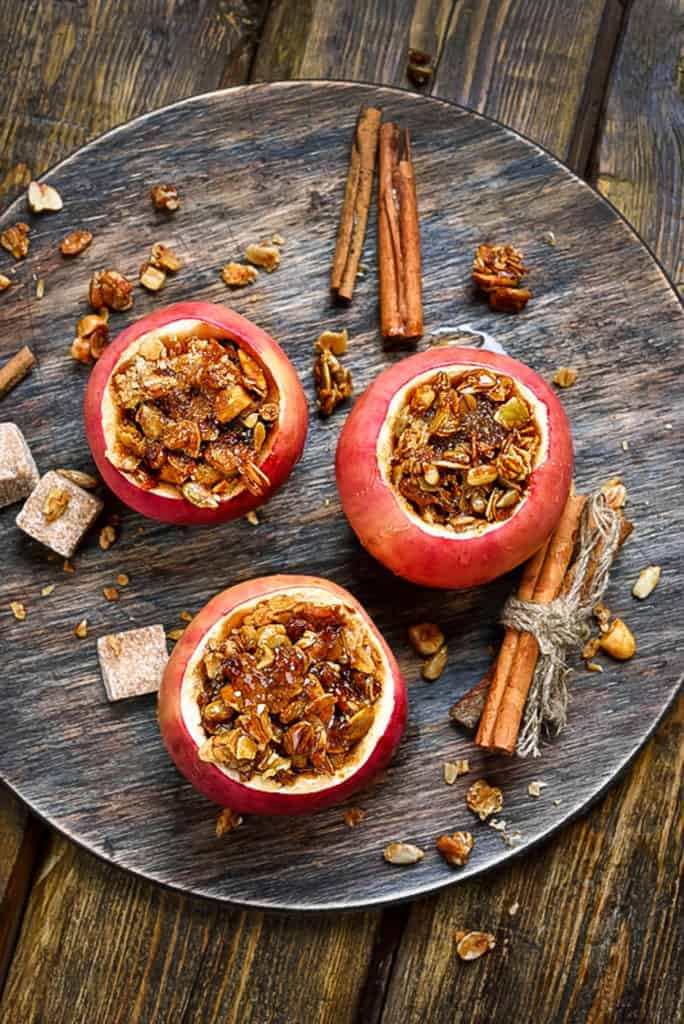 baked cinnamon apples stuffed with spiced sprouted quinoa, granola, nuts, fruit - top view on a grey plate