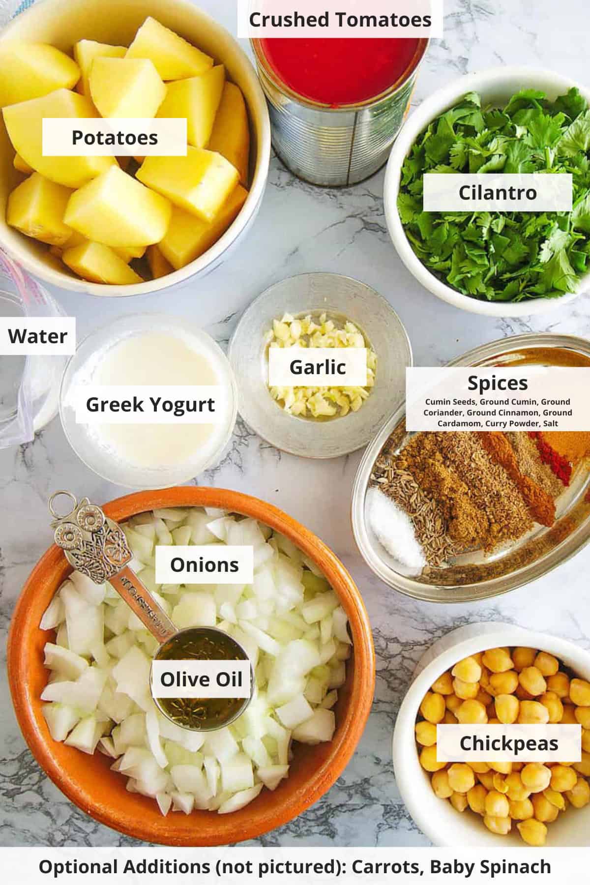 Ingredients for chickpea and potato curry recipe on a marble countertop.
