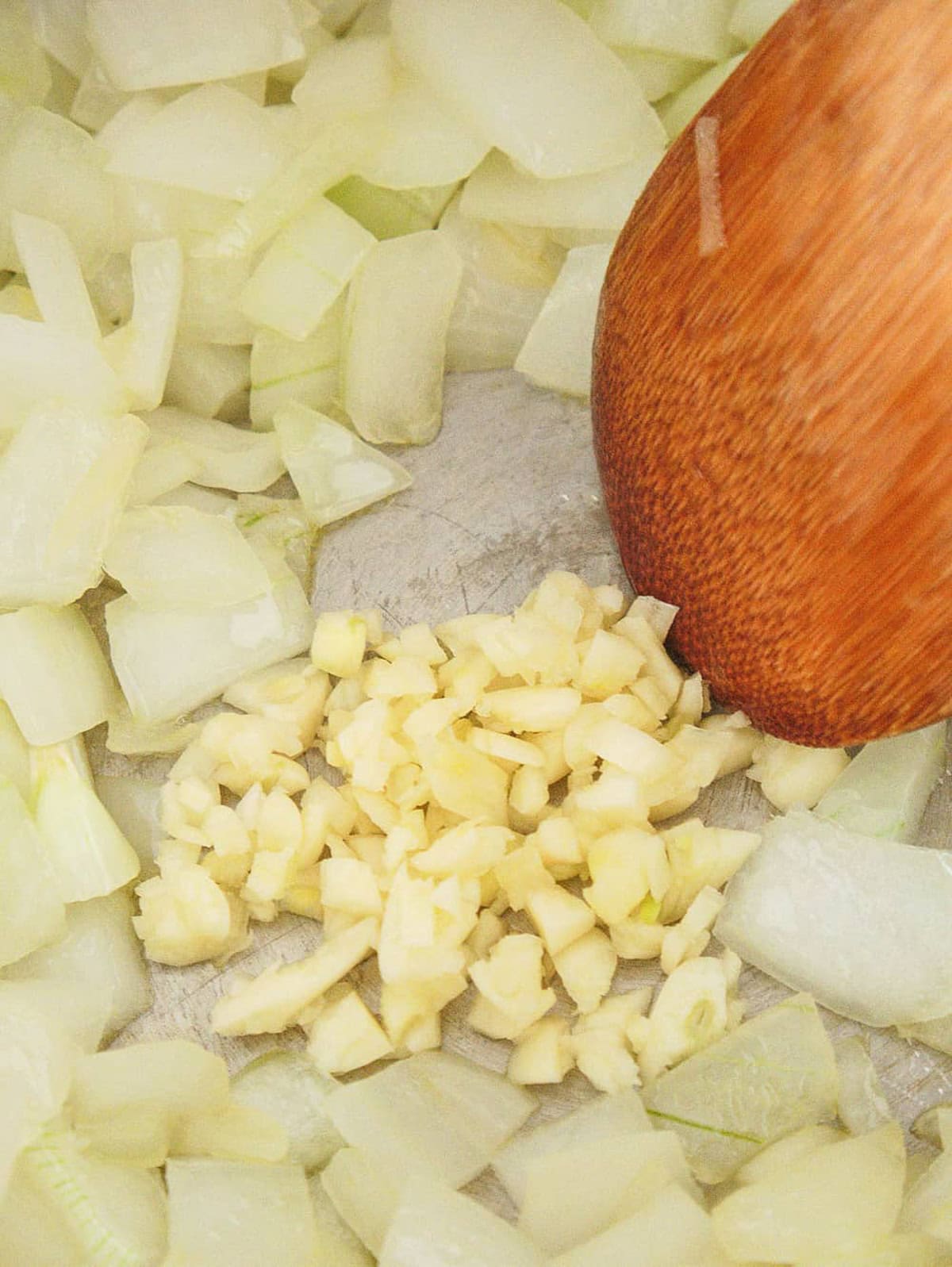 Onions and garlic cooking in a pot on the stove.
