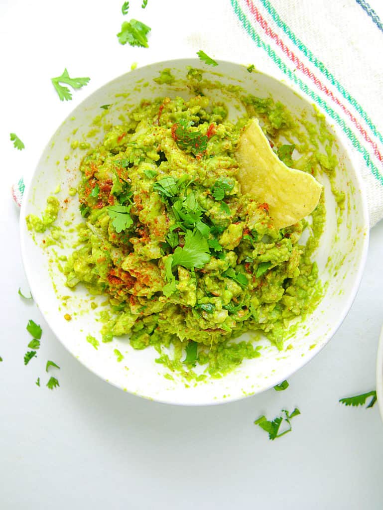 healthy guacamole recipe in bowl with chip