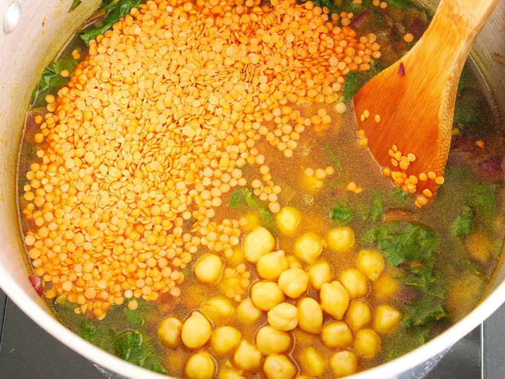 stirring lentils and chickpeas into soup