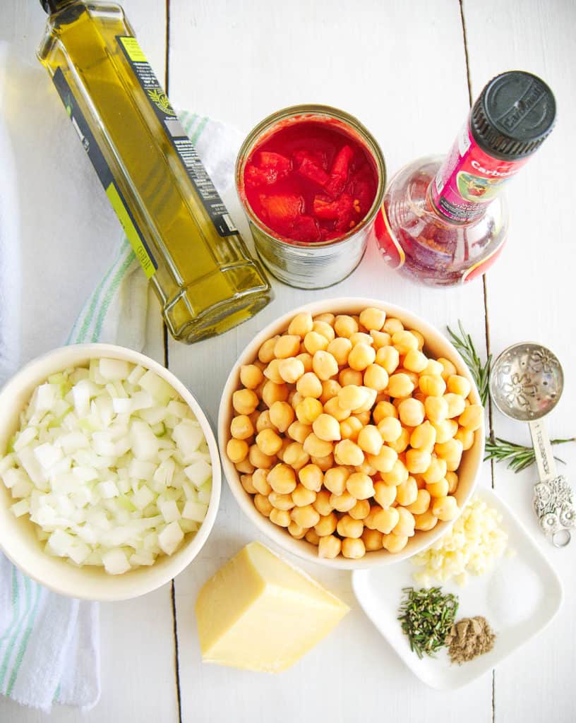 italian chickpea soup ingredients - olive oil, tomatoes, onions, chickpeas, parmesan, spices