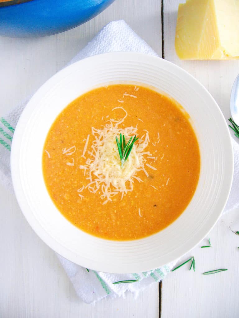 italian chickpea soup in a white bowl topped with parmesan cheese, top view