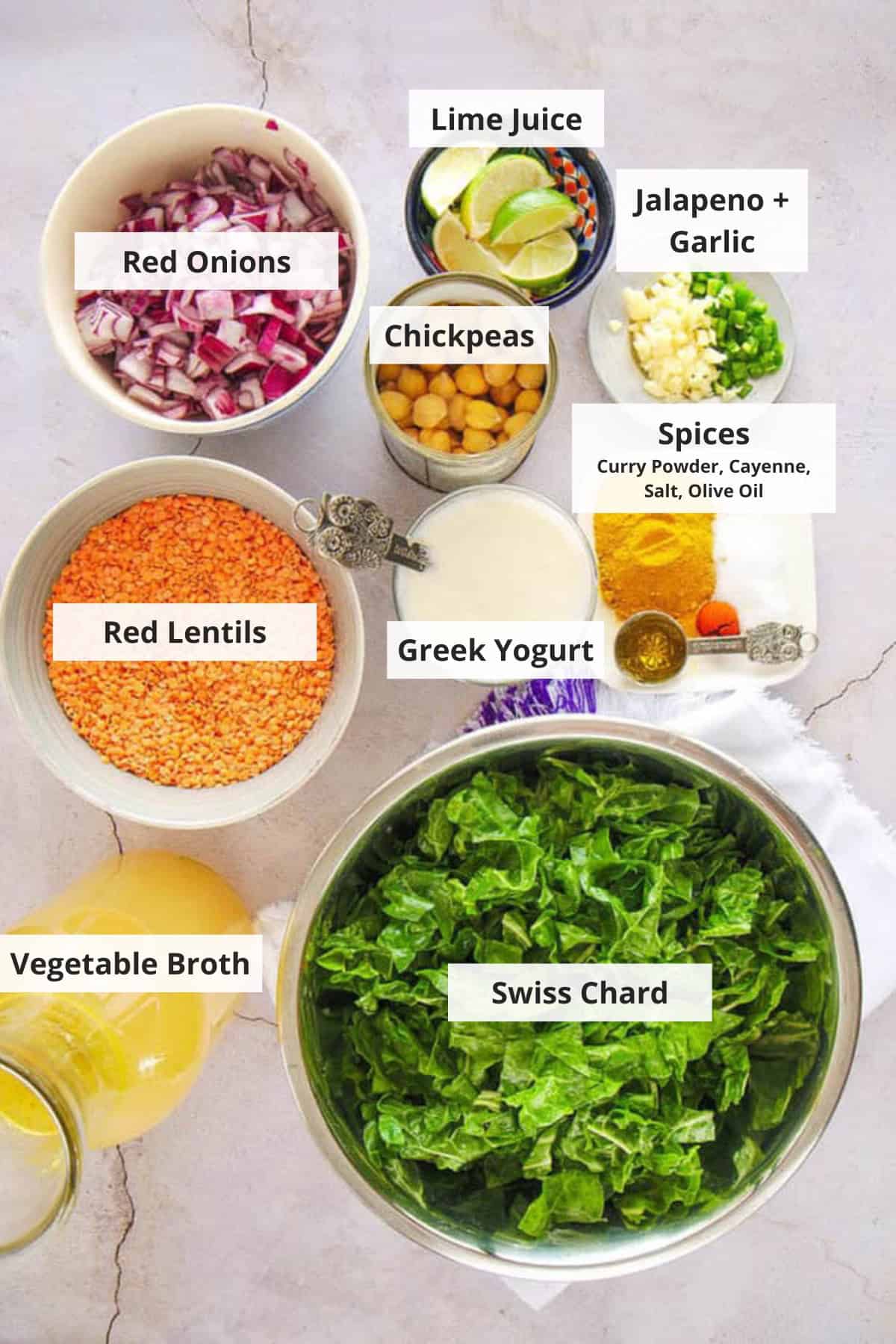 Ingredients for lentil swiss chard soup on a marble countertop.