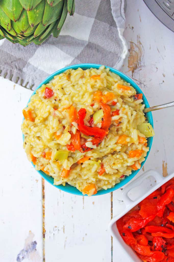 Instant pot risotto with roasted red peppers and artichokes, served in a bowl, top view