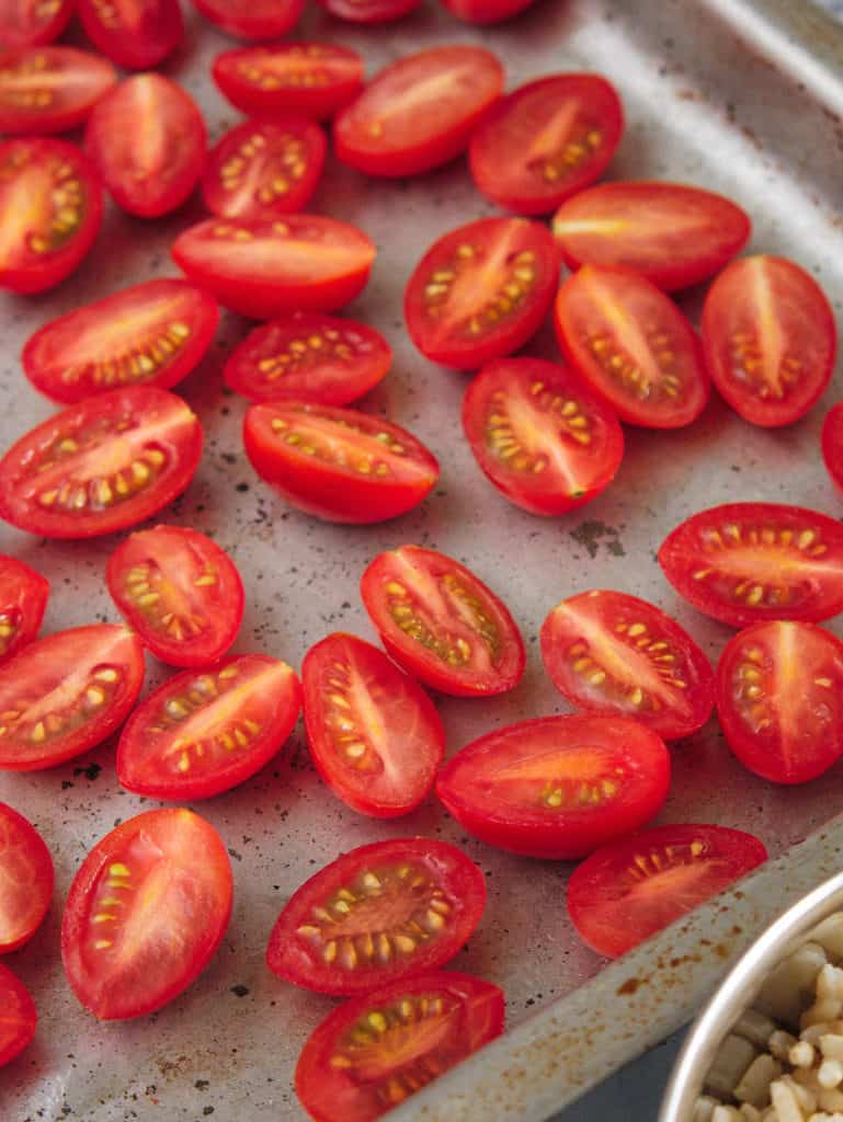 grape tomatoes sliced on a baking sheet
