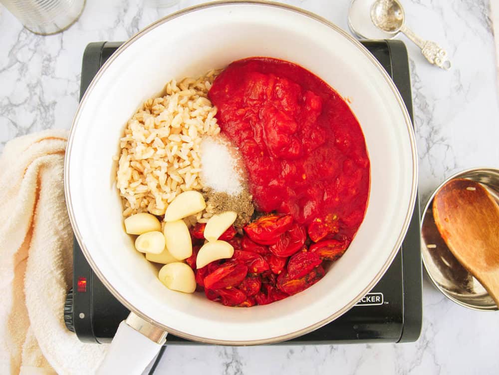 garlic, tomatoes, rice, seasonings in a pot