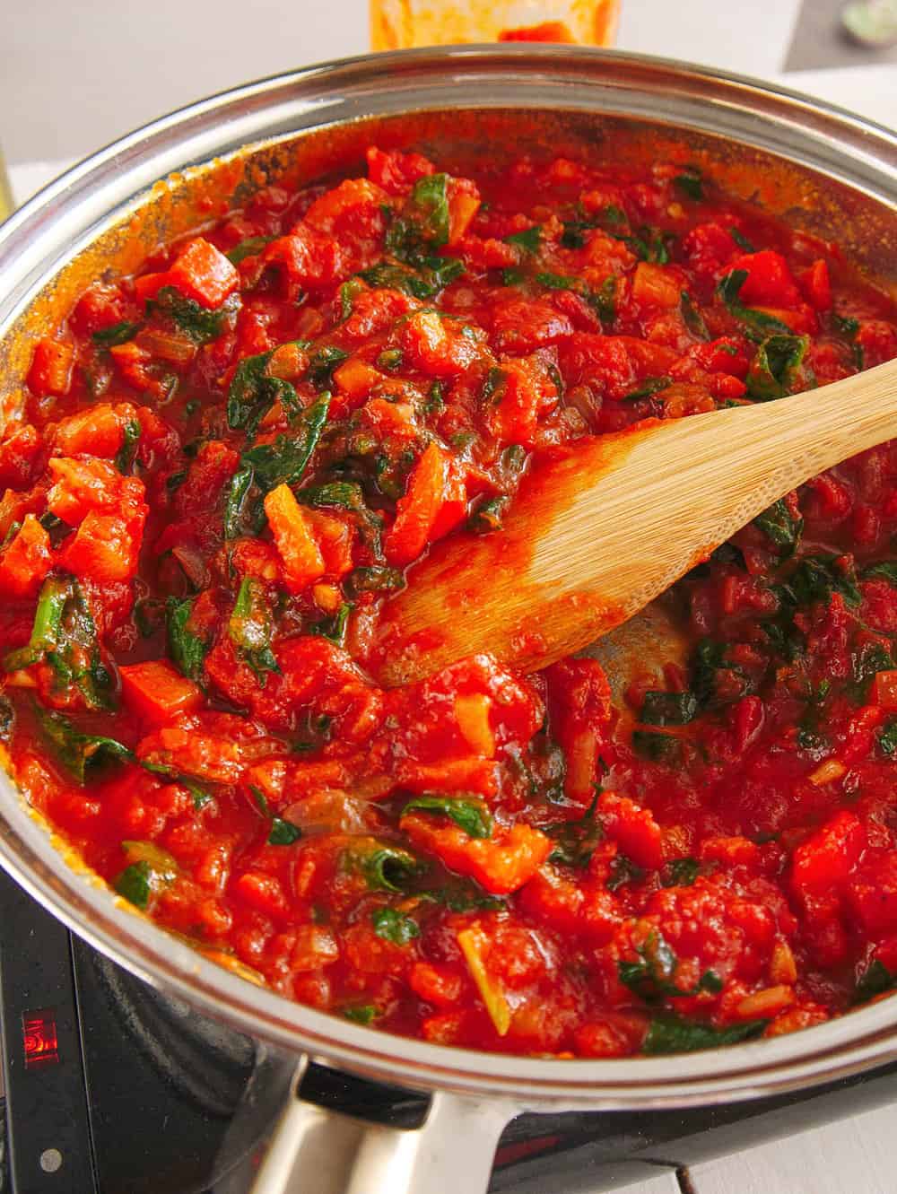 Glass jar filled with soaked dried chickpeas in water sitting on a blue striped towel.