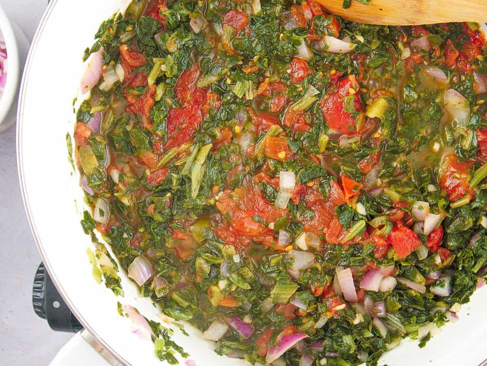 tomatoes added to spinach mixture in pan