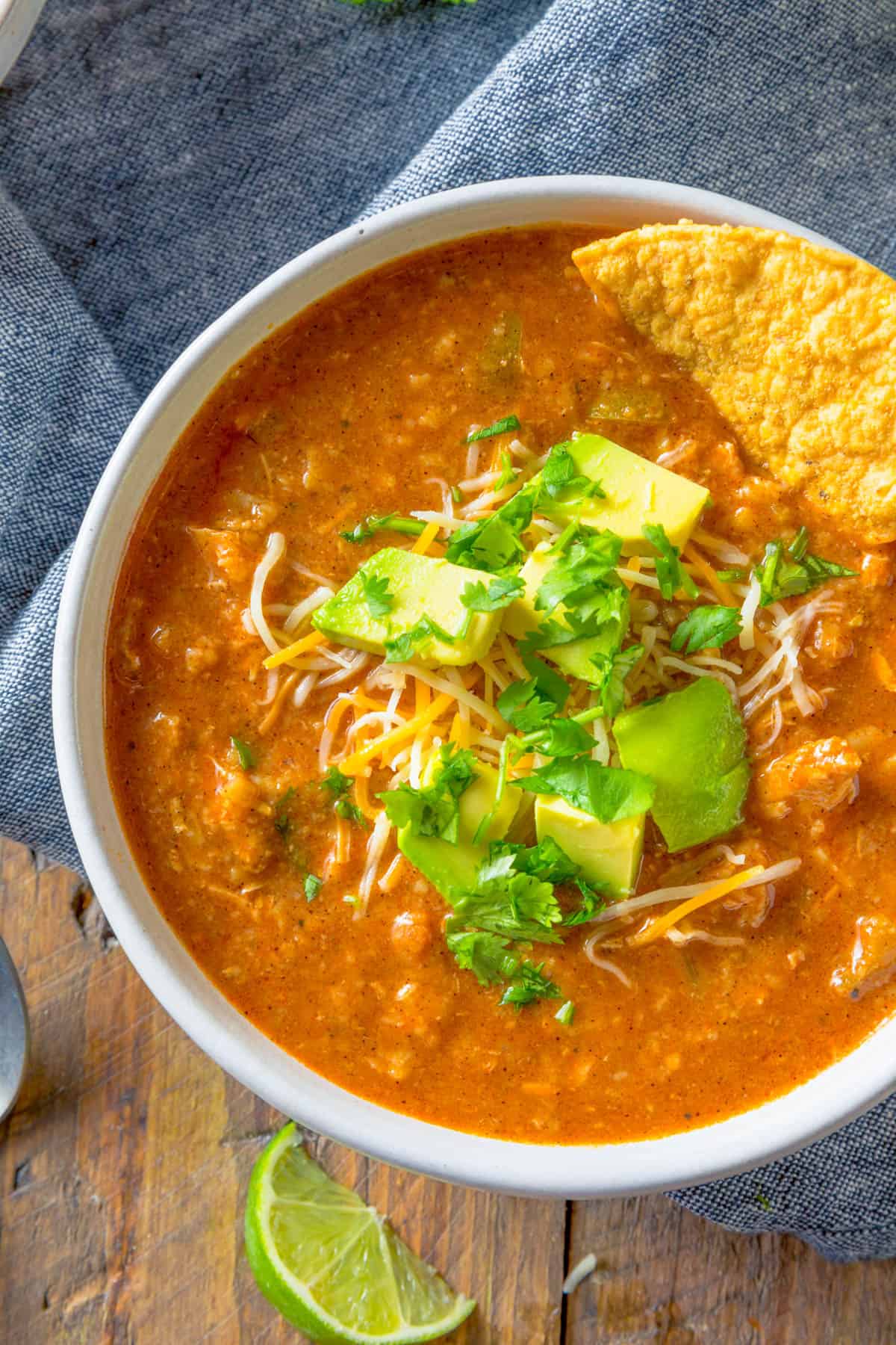 Mexican bean soup served in a bowl topped with avocado and tortilla chips.