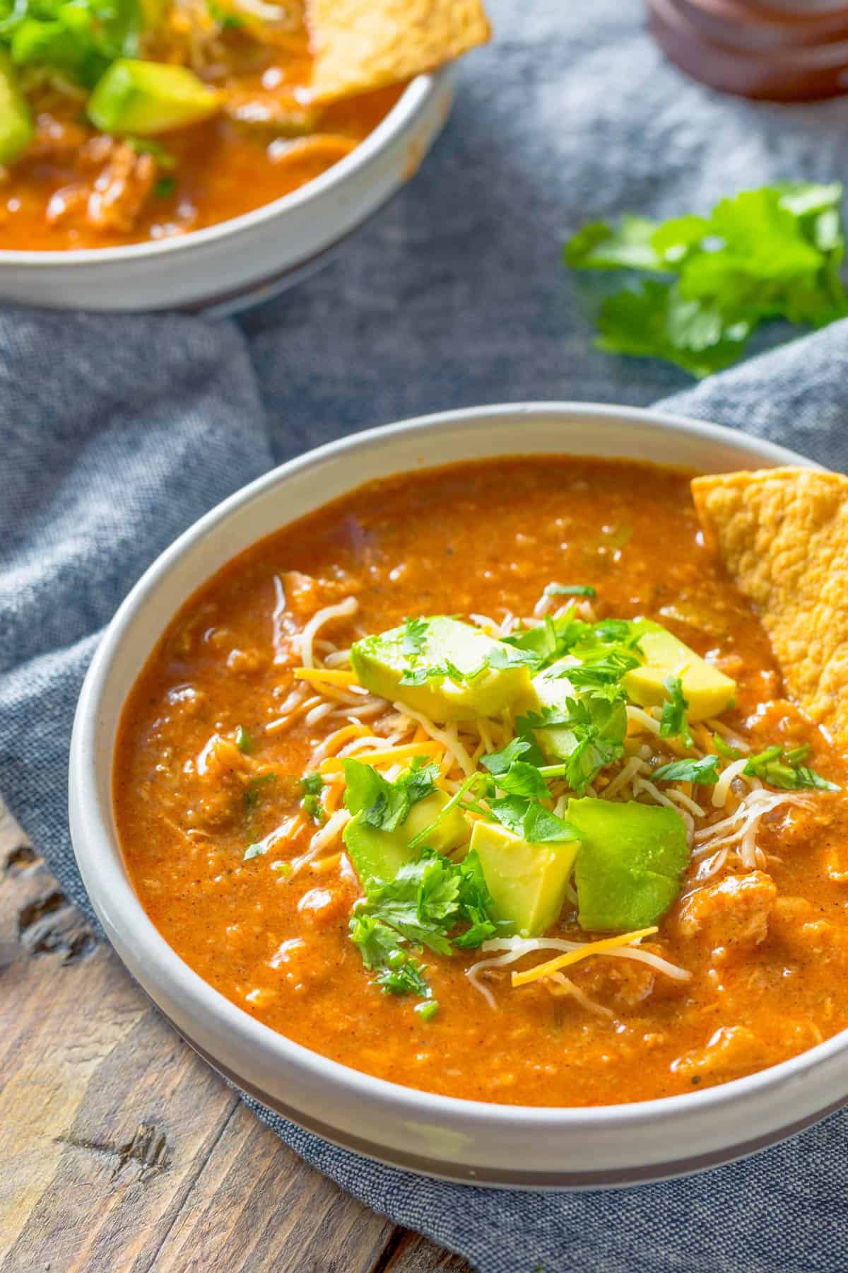 Mexican bean soup served in a bowl topped with avocado and tortilla chips.