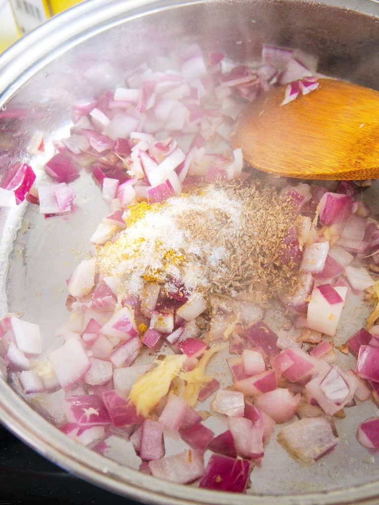 spices added to pan with onion and ginger